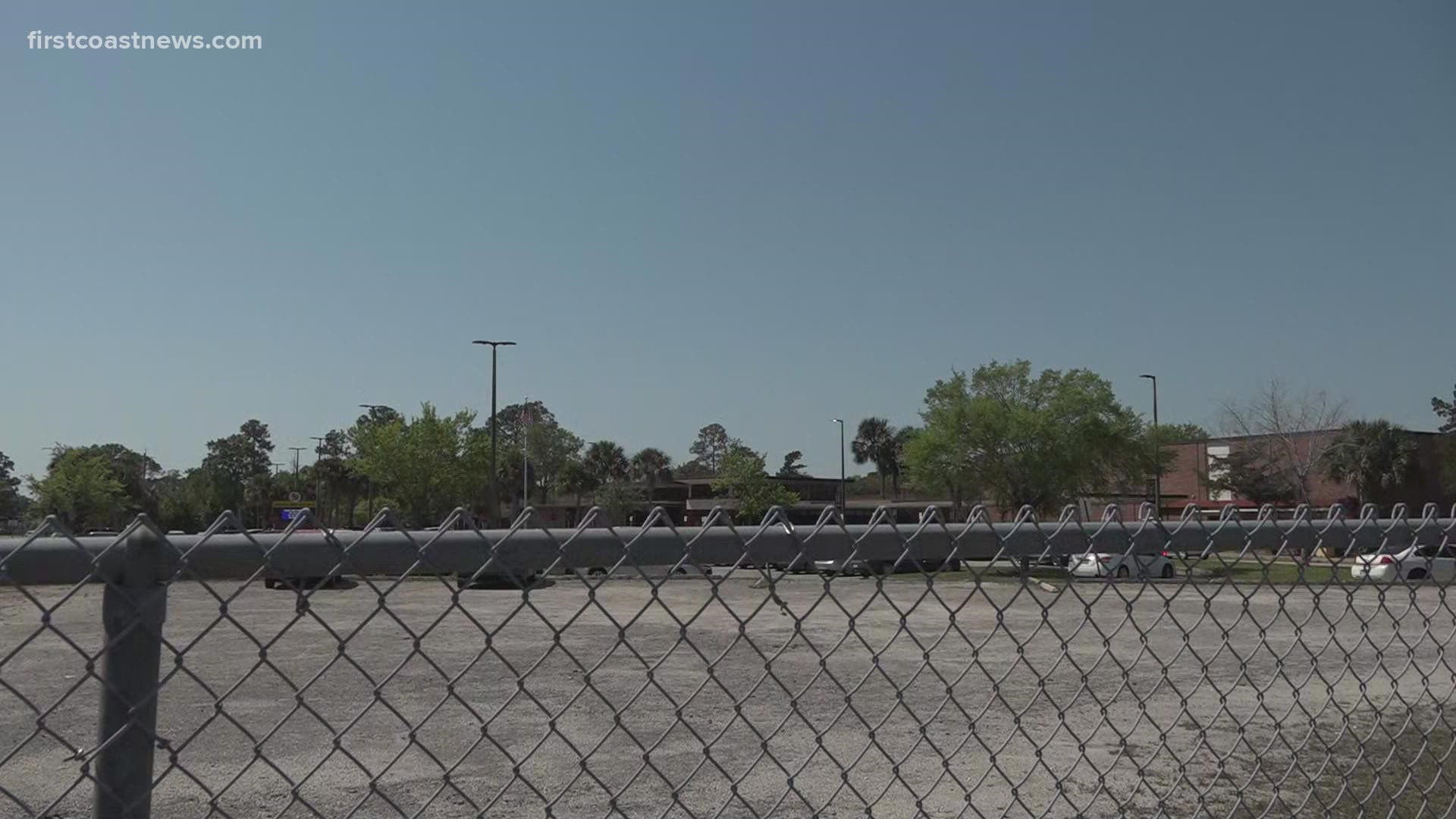 Three people hopped the fence, but two of them, both students, have been apprehended. One of the people may have been armed, the principal said.