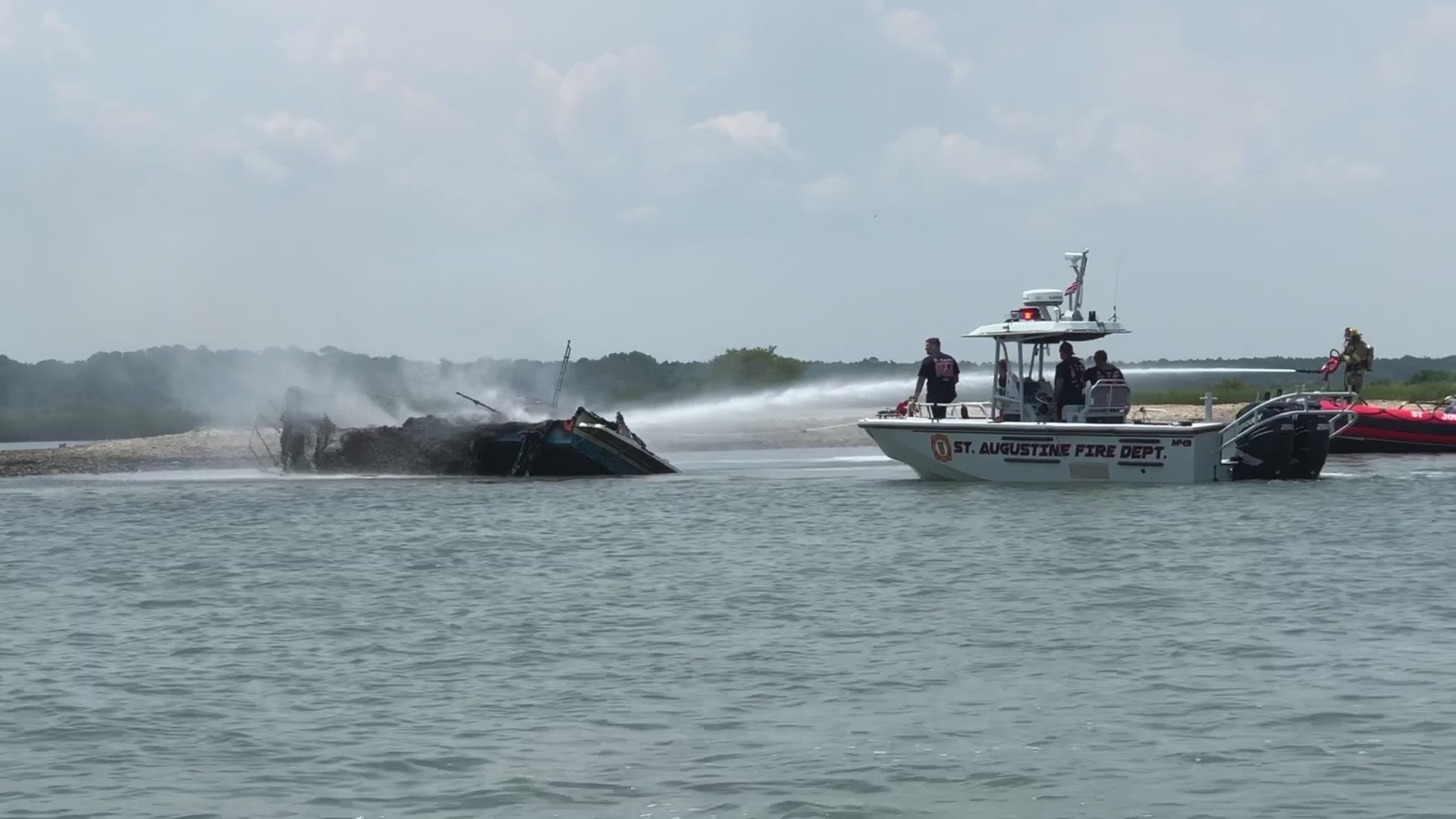 Fire rescue hosed down a boat Wednesday after it was engulfed in flames in the Intracoastal Waterway and Matanzas Inlet.