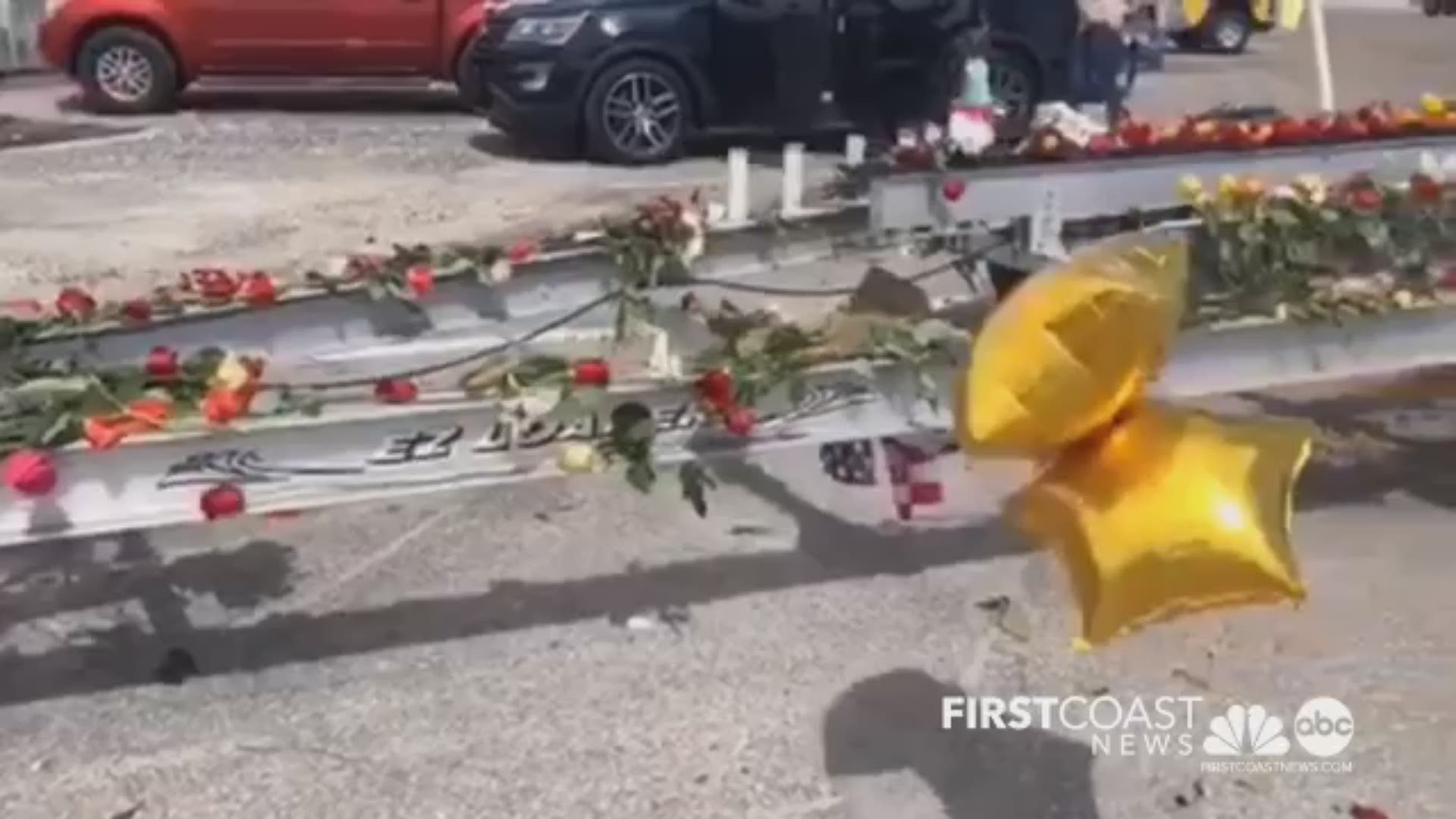 The boat trailer of a missing Jacksonville Fire and Rescue firefighter lost at sea has been turned into a makeshift memorial adorned with flowers, ribbons, candles and balloons.