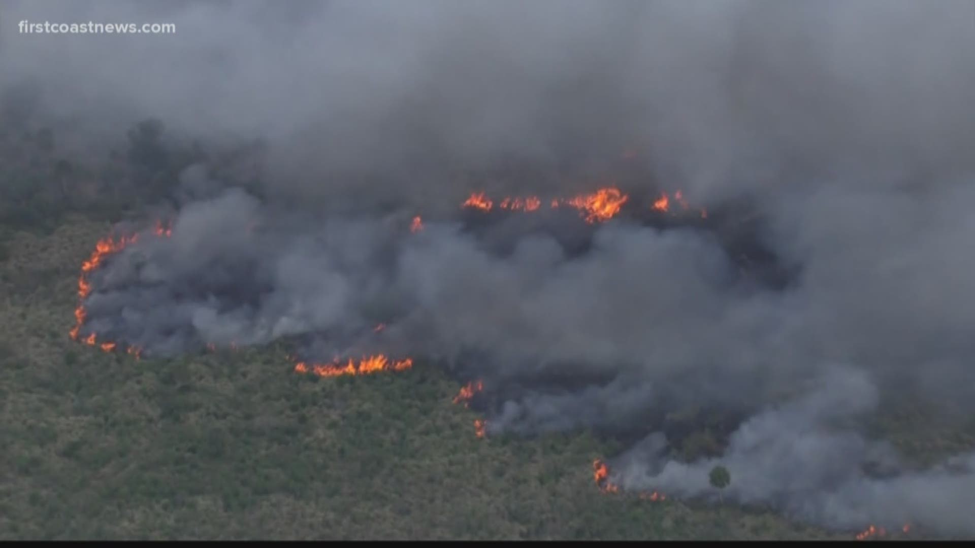 Fire crews are battling a multi-acre brush fire threatening several homes in Central Florida.