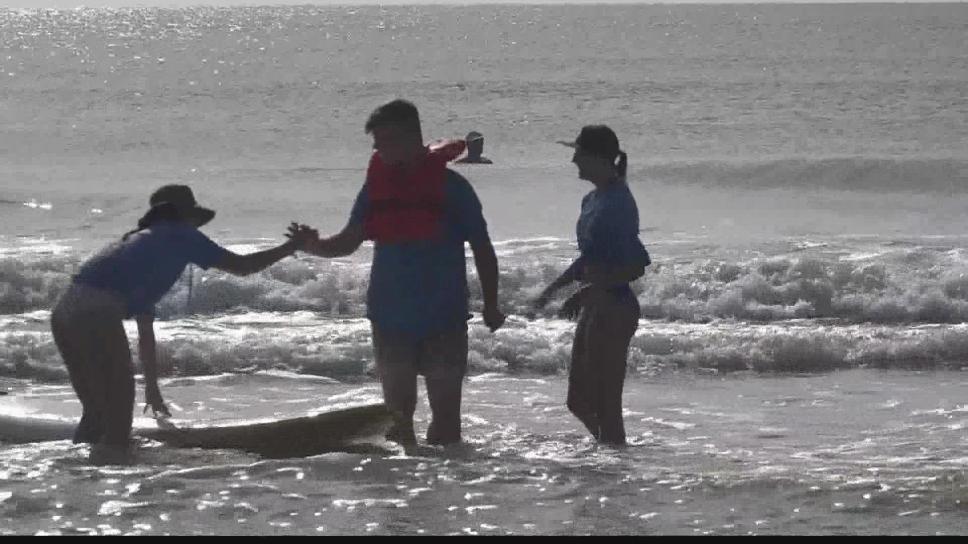 Around one hundred people were on the beach Tuesday cheering and giving high fives to the young people surfing in the HEAL Foundation camp.