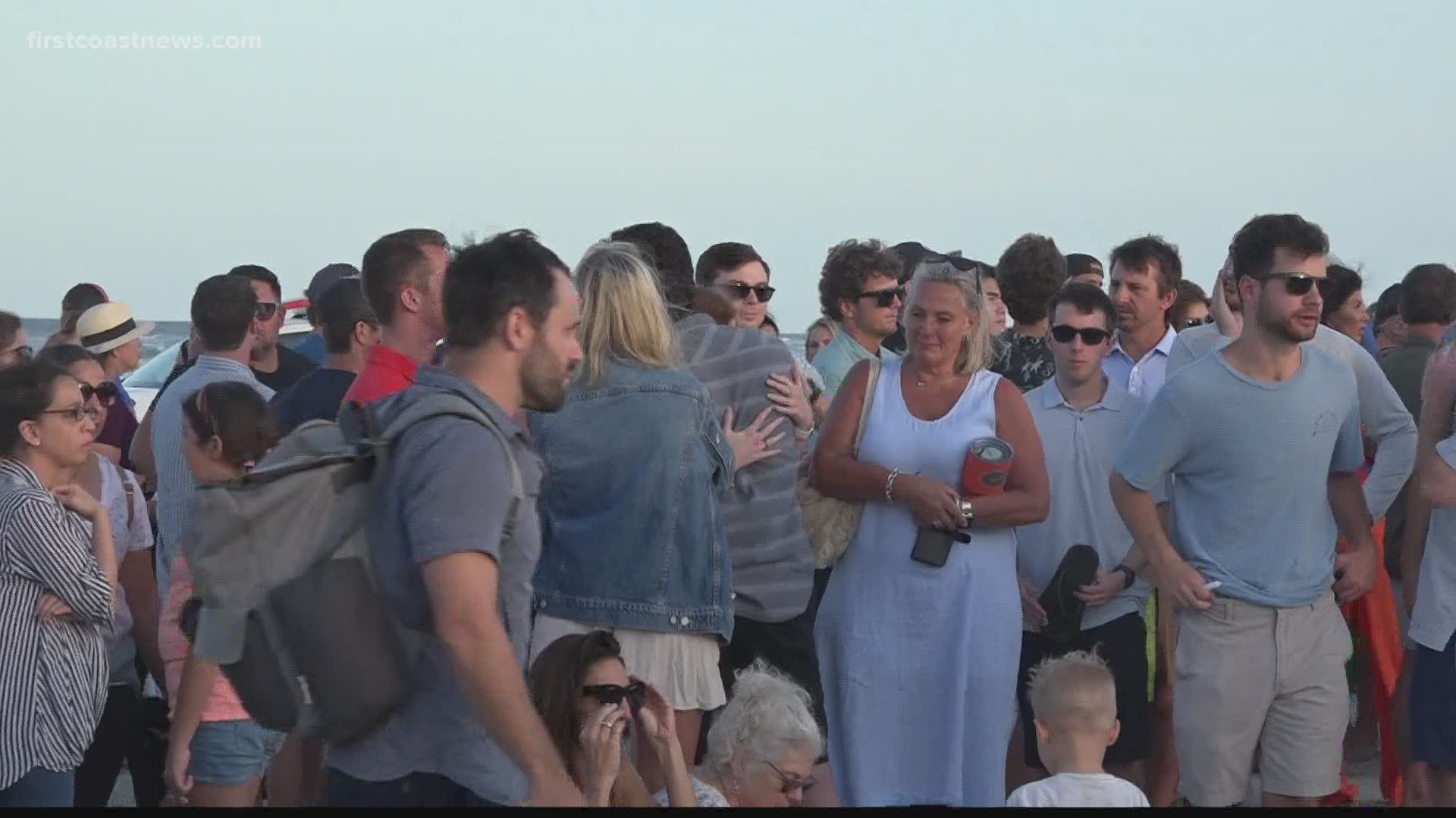 Hundreds of people gathered on Neptune Beach to grieve and remember Timothy Obi, a father and husband who died while diving off the coast of Mayport.