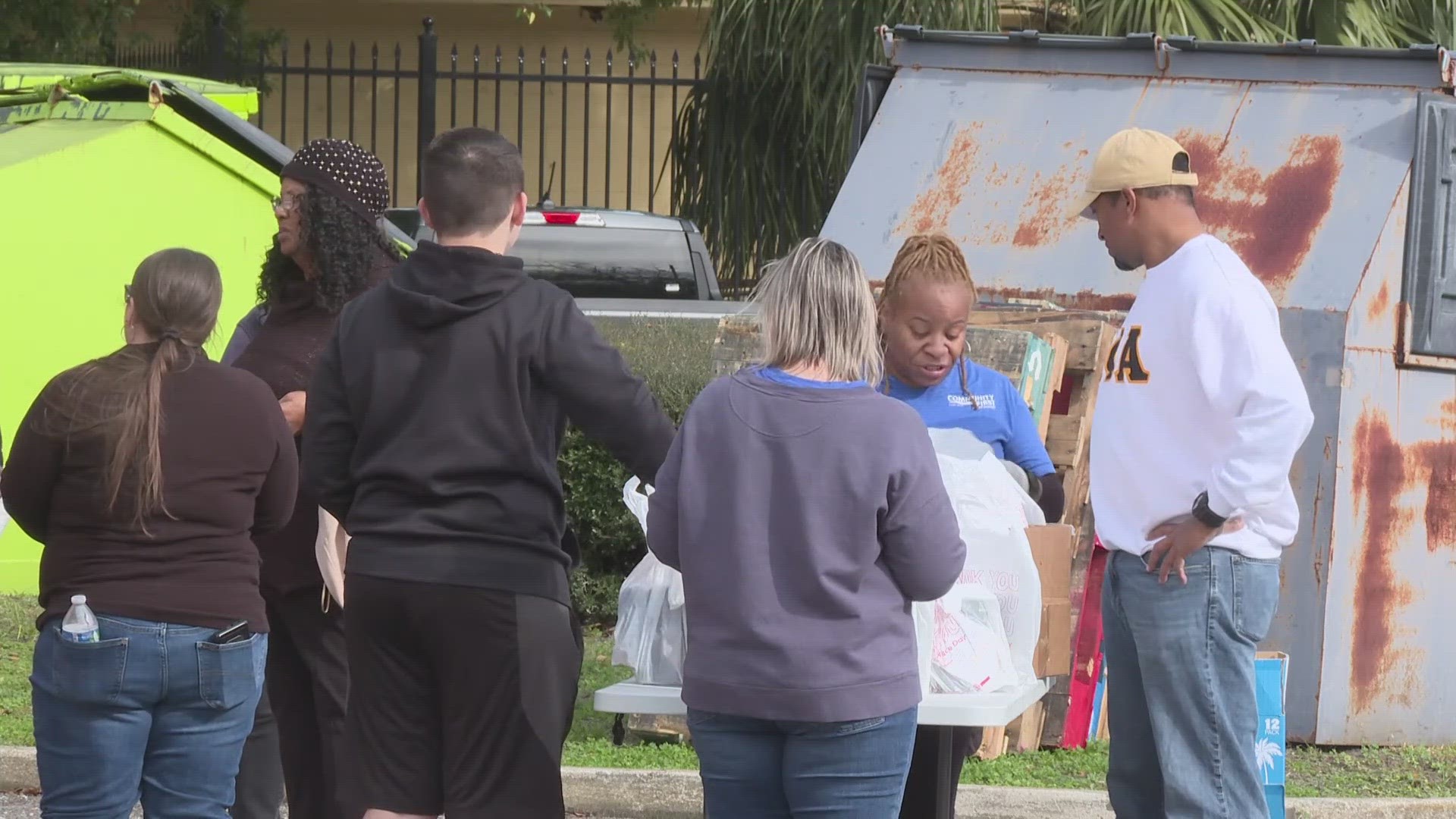 Volunteers with the Schell-Sweet Community Resource Center, Community First Cares Center & Feeding Northeast Florida, team up to give families free food in New Town.