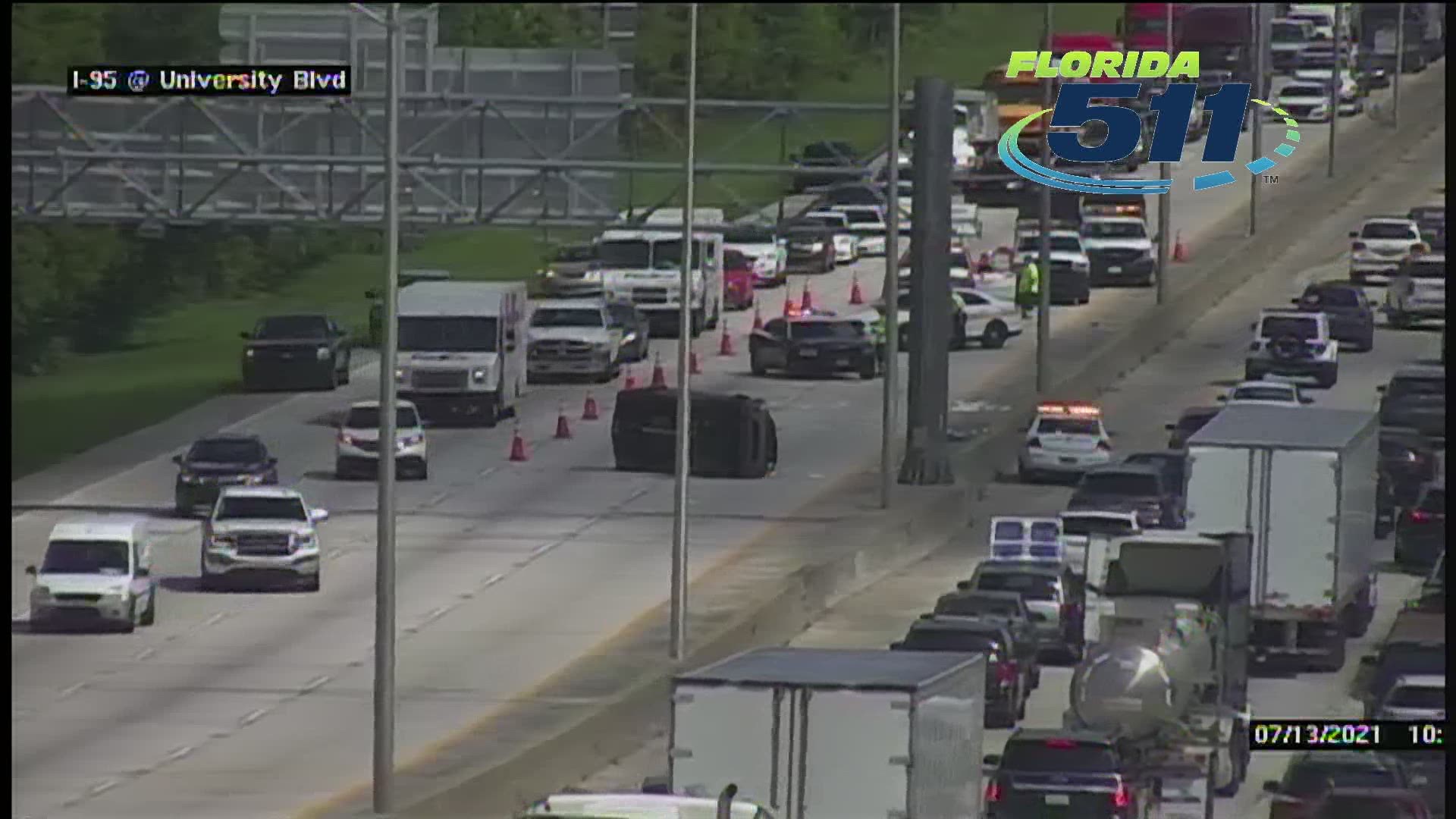 A vehicle can be seen flipped on its side on I-95 south, blocking two left lanes. Traffic is also moving slowly heading north past the crash.