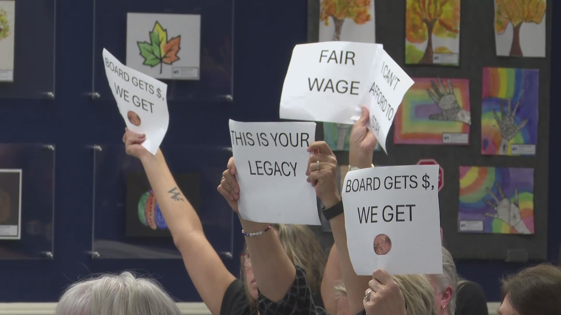 The Clay County School Board unanimously approved a budget proposal despite strong opposition from educators holding signs reading 'shame' and 'A district, F pay.'
