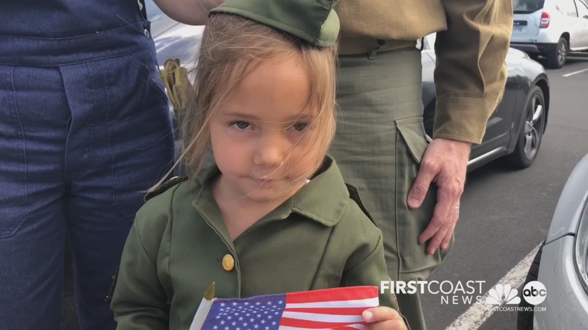 This 5-year-old girl is waving the American flag as a sign of respect. How cute!