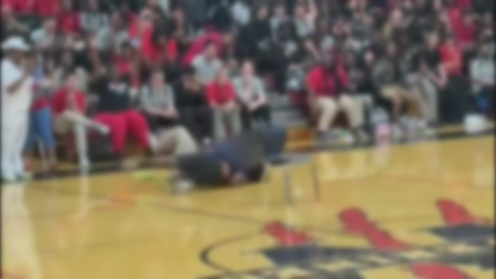 A man the district identified as a teacher is seen in the video picking up the student and throwing her to the ground during a game of musical chairs.