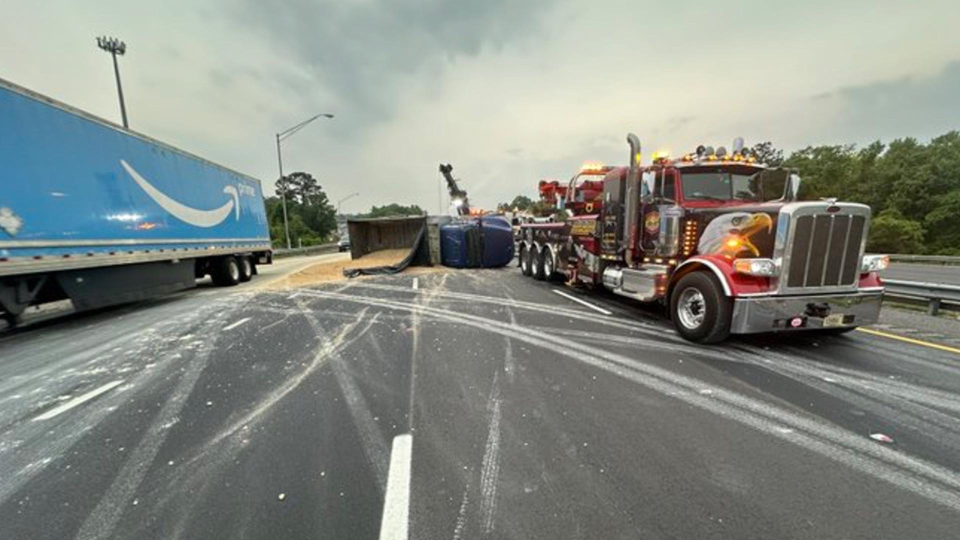 Drivers should use caution in the area as the overturned dump truck has spilled sand onto the interstate.