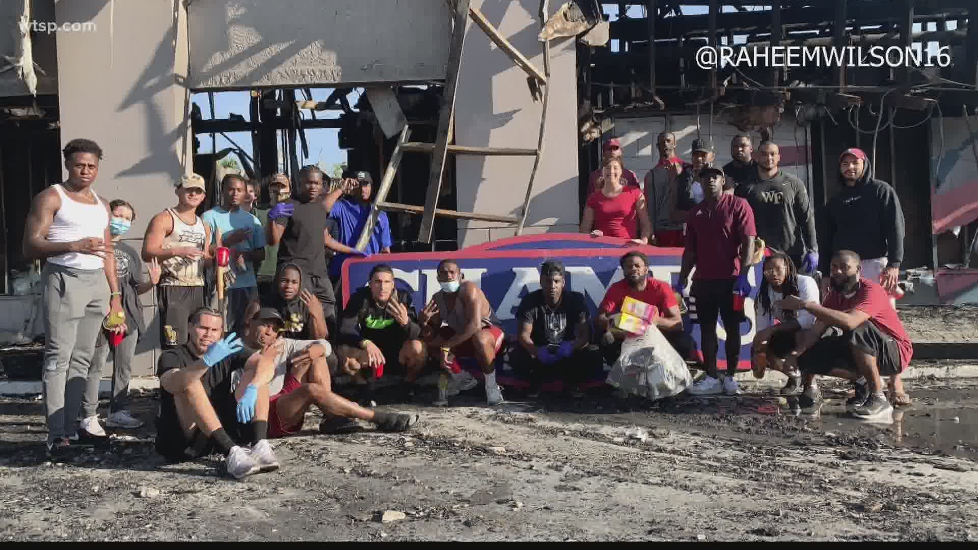 About a dozen Tampa-area football players helped to clean up the Champs Sports store after it was destroyed in a fire during protests Saturday.